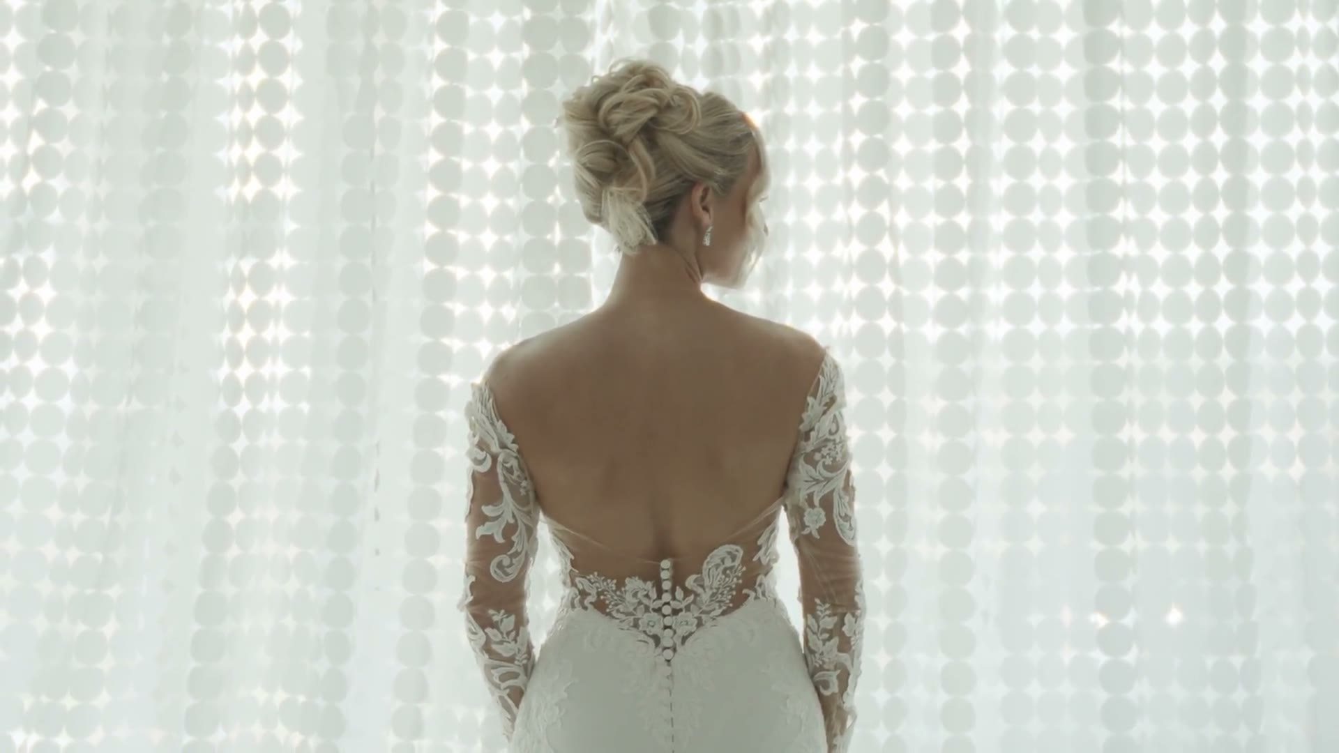 A bride in a lace dress in soft window light