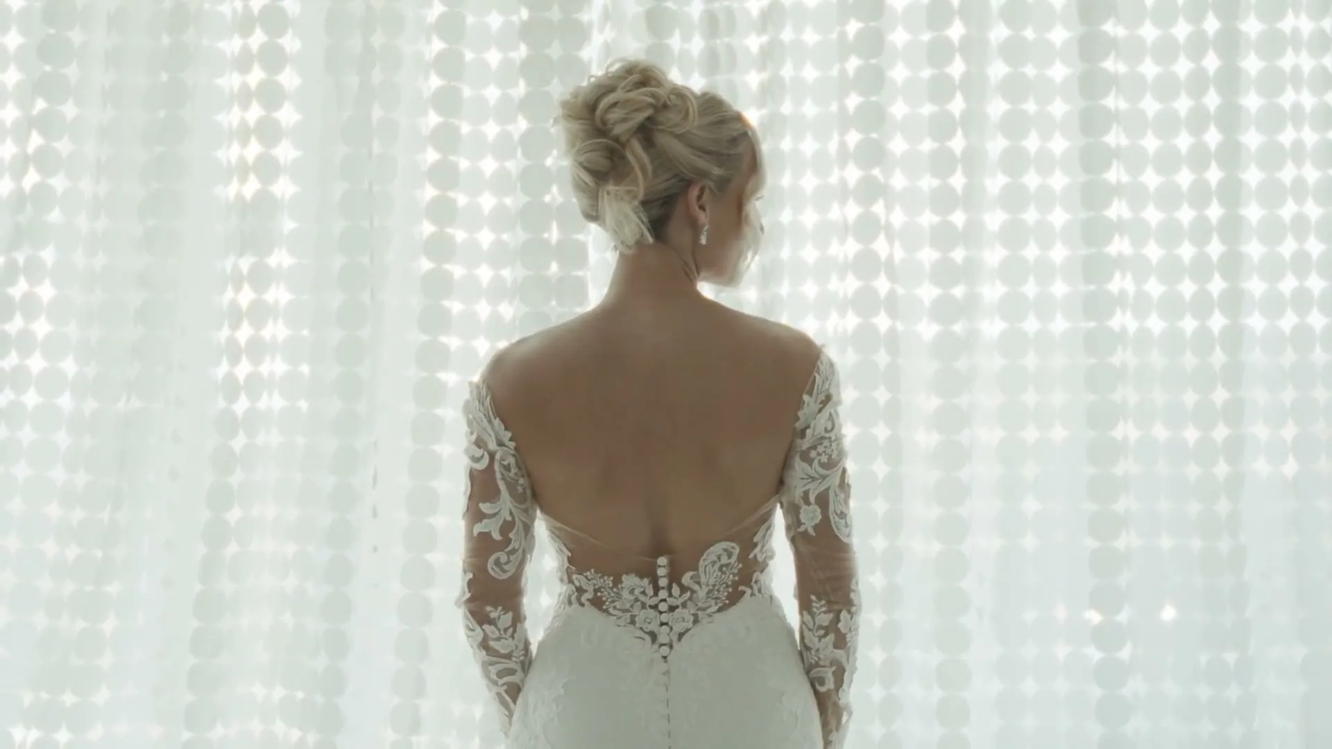 A bride in a lace dress in soft window light