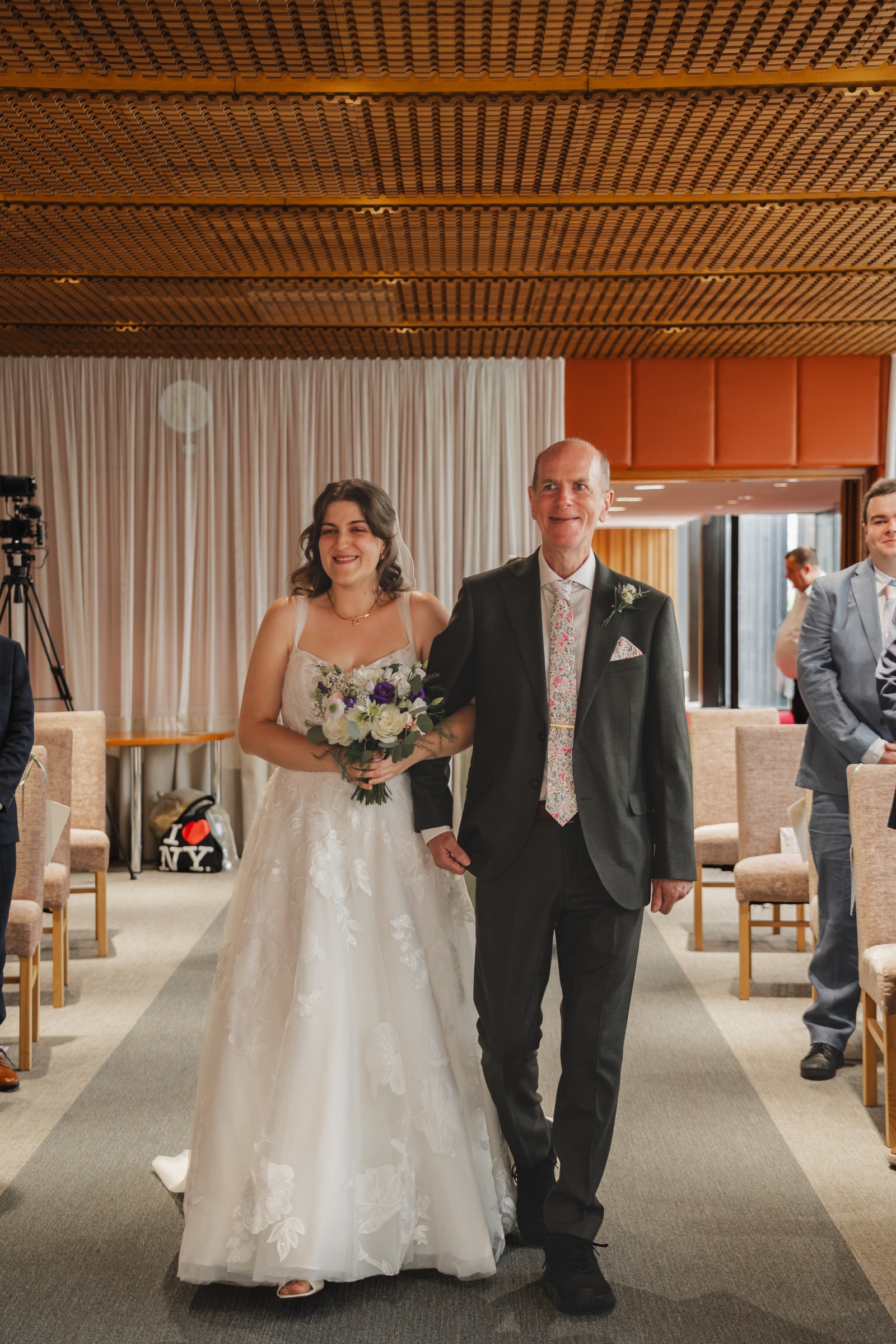 A bride walking with a family member during a small city wedding