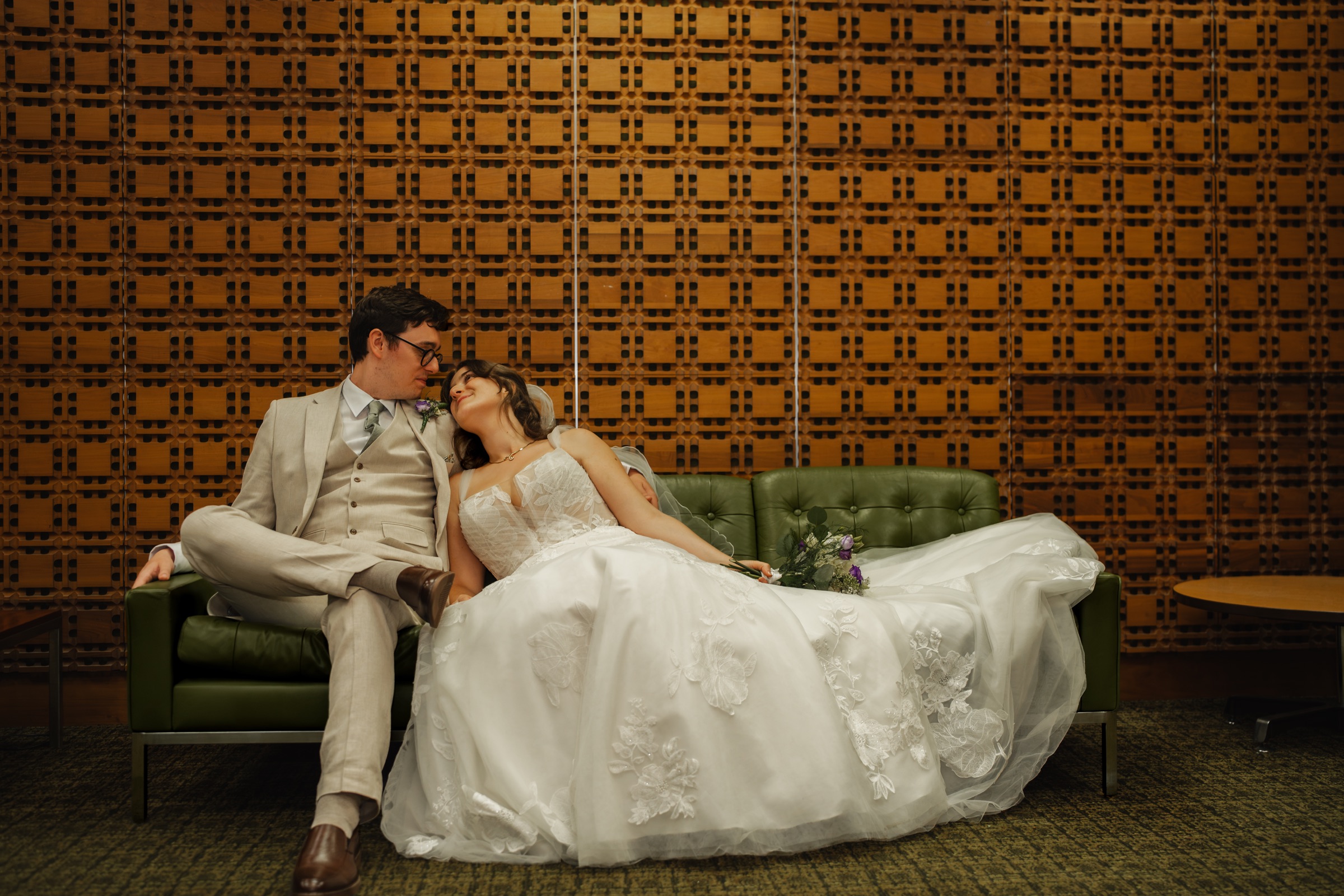 Ben and Tiffany seated together on a green sofa