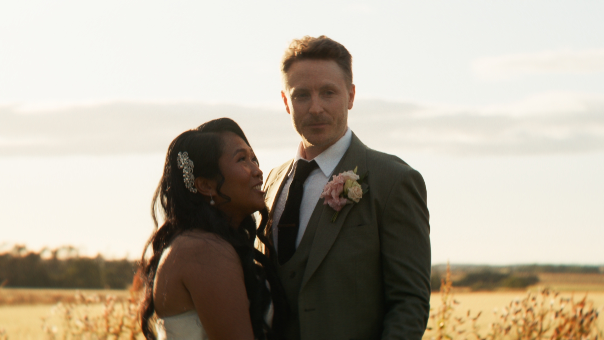 Chris and April smiling together in warm evening light at Newton Hall