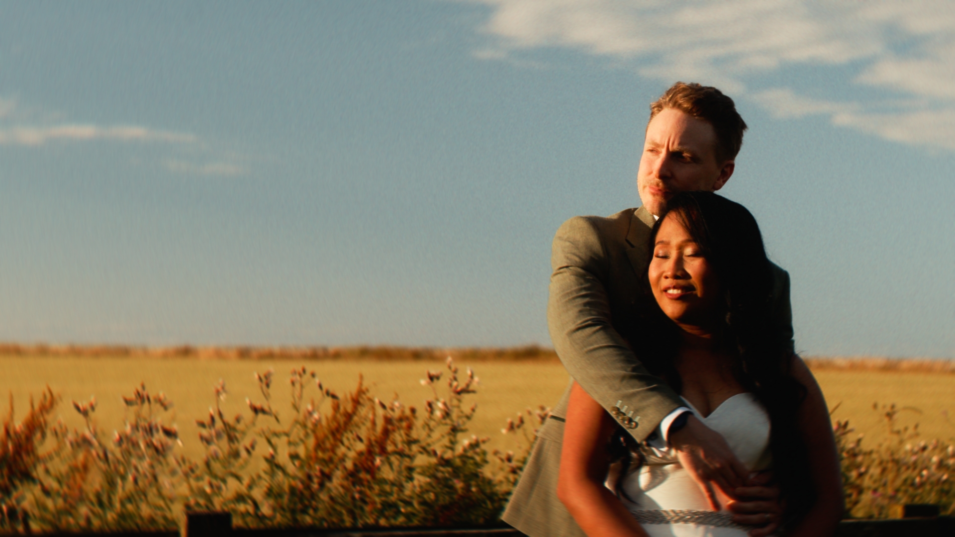 Chris holding April in a field at Newton Hall during golden hour