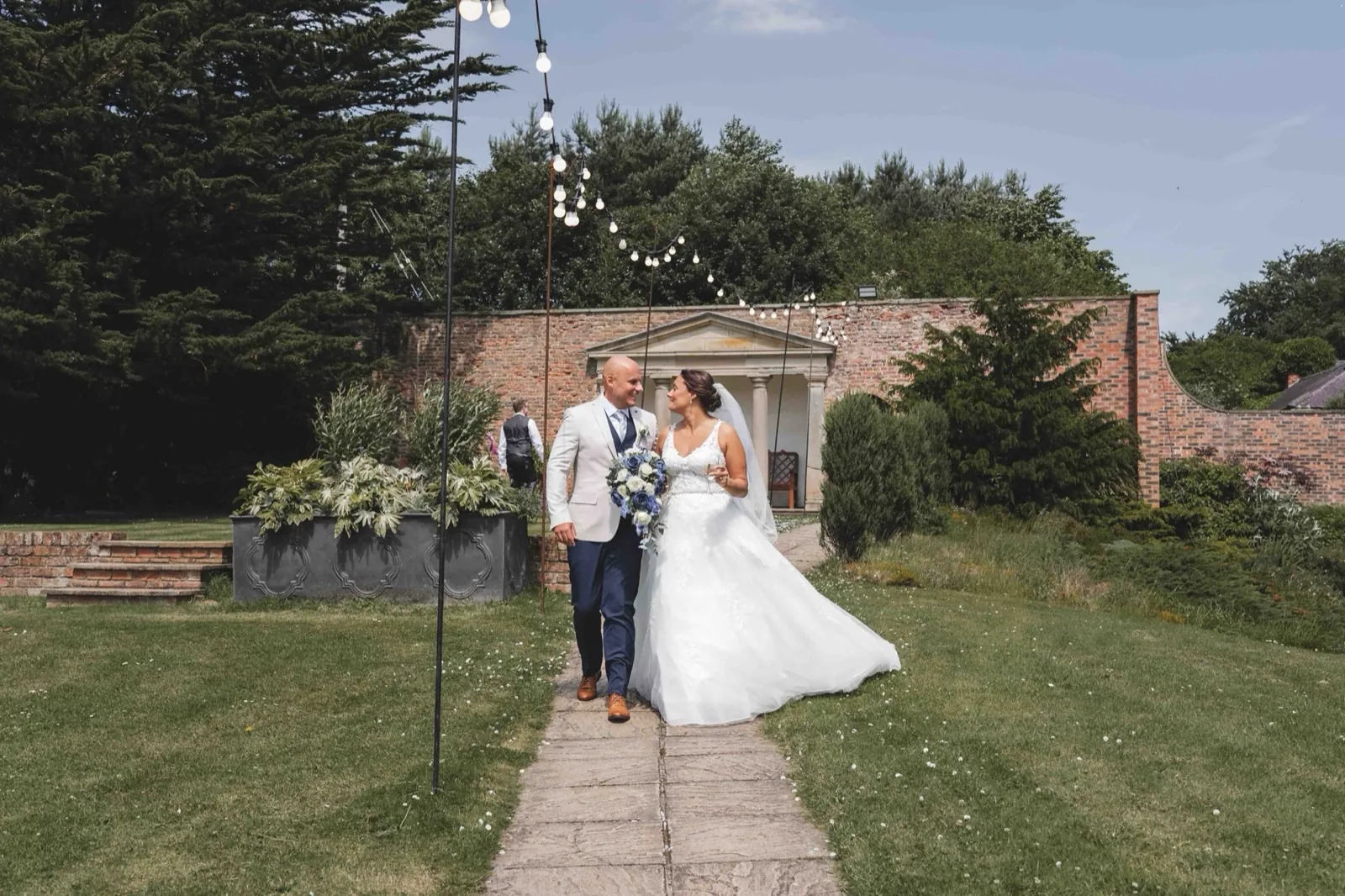 Lauren and John holding hands at Hardwick Hall on their wedding day
