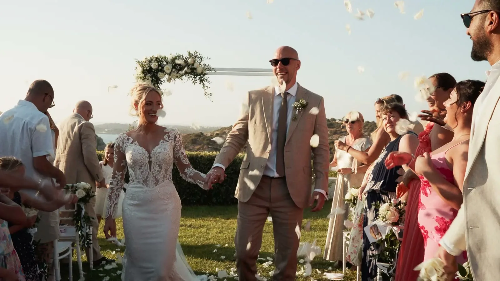 Ash and Katie walking back down the aisle after their outdoor wedding ceremony in Greece