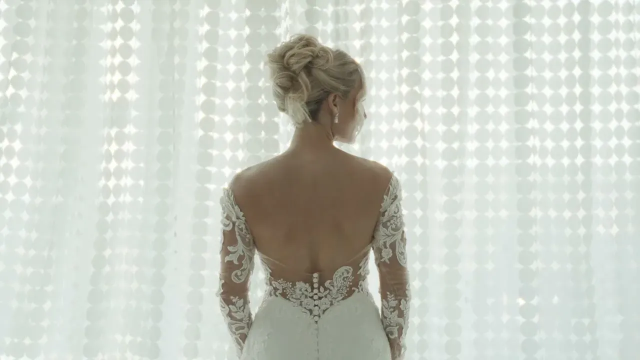 Katie in her wedding dress by a light-filled window before the ceremony