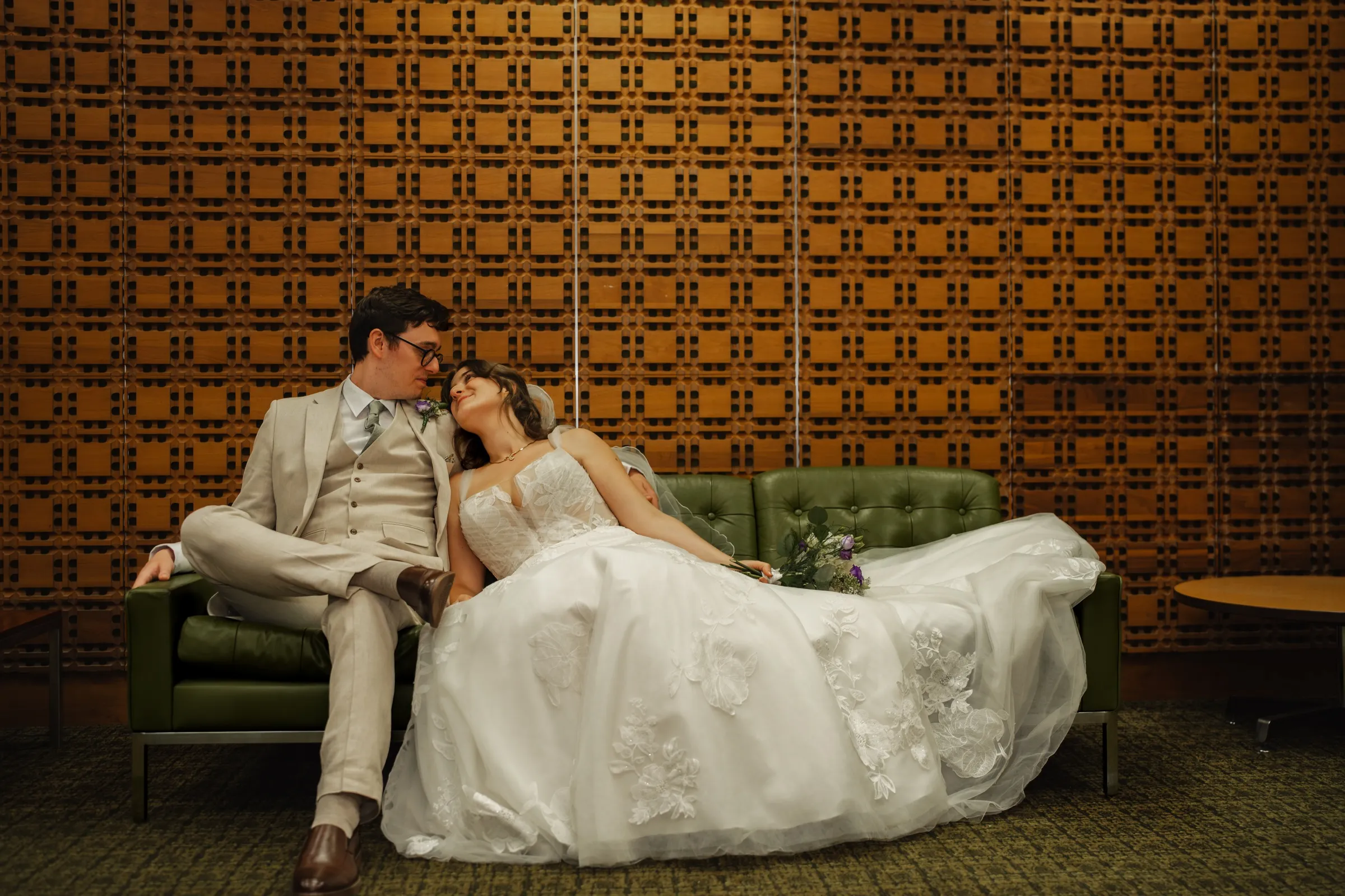 Ben and Tiffany seated together on a green sofa