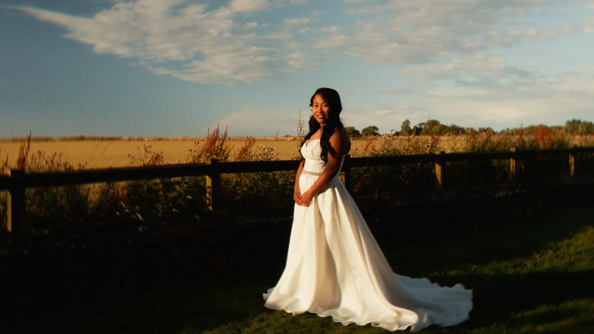 A bride at Newton Hall in golden-hour light after a rainy wedding day