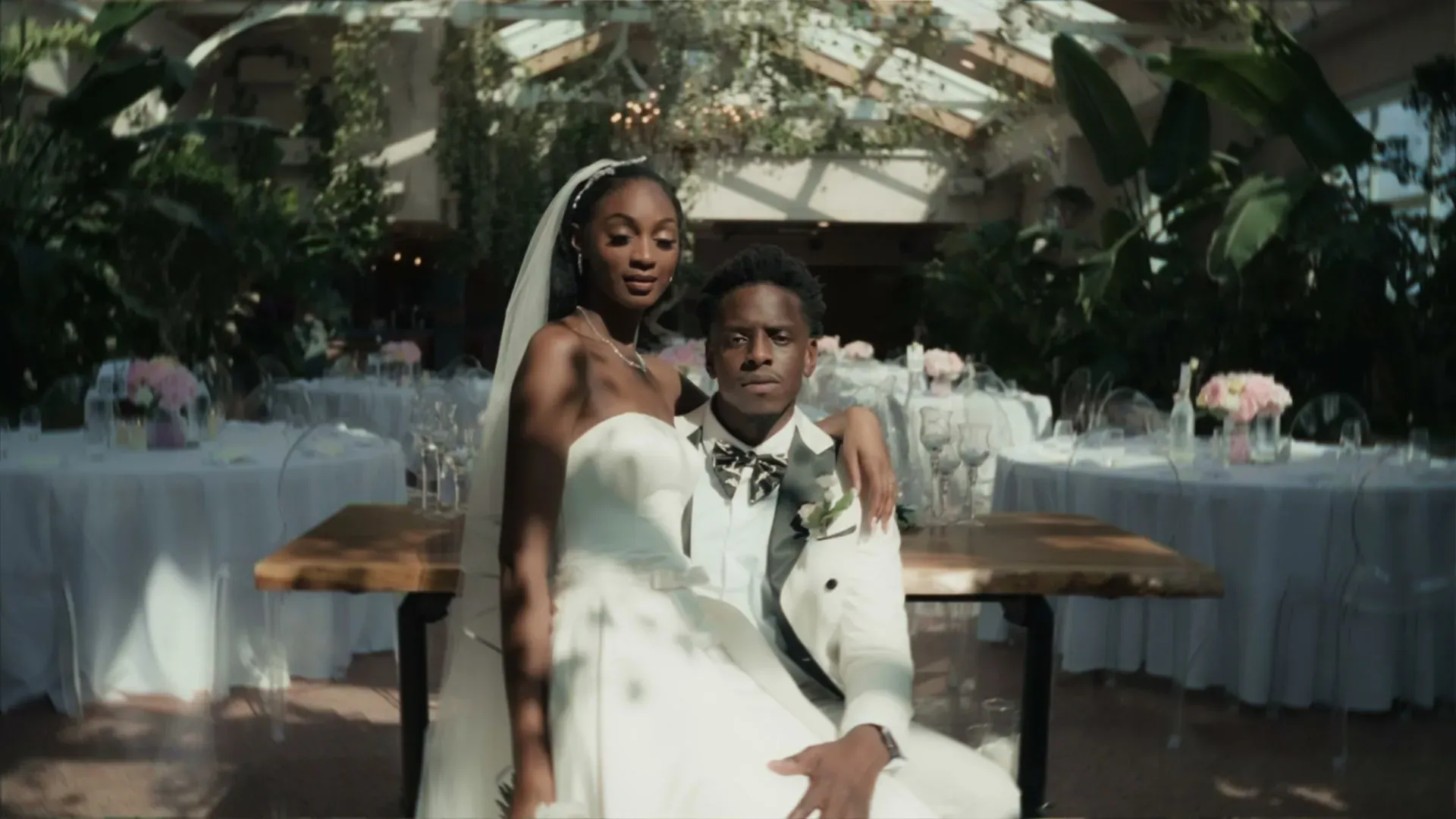 A couple in a glasshouse wedding venue, editorial portrait