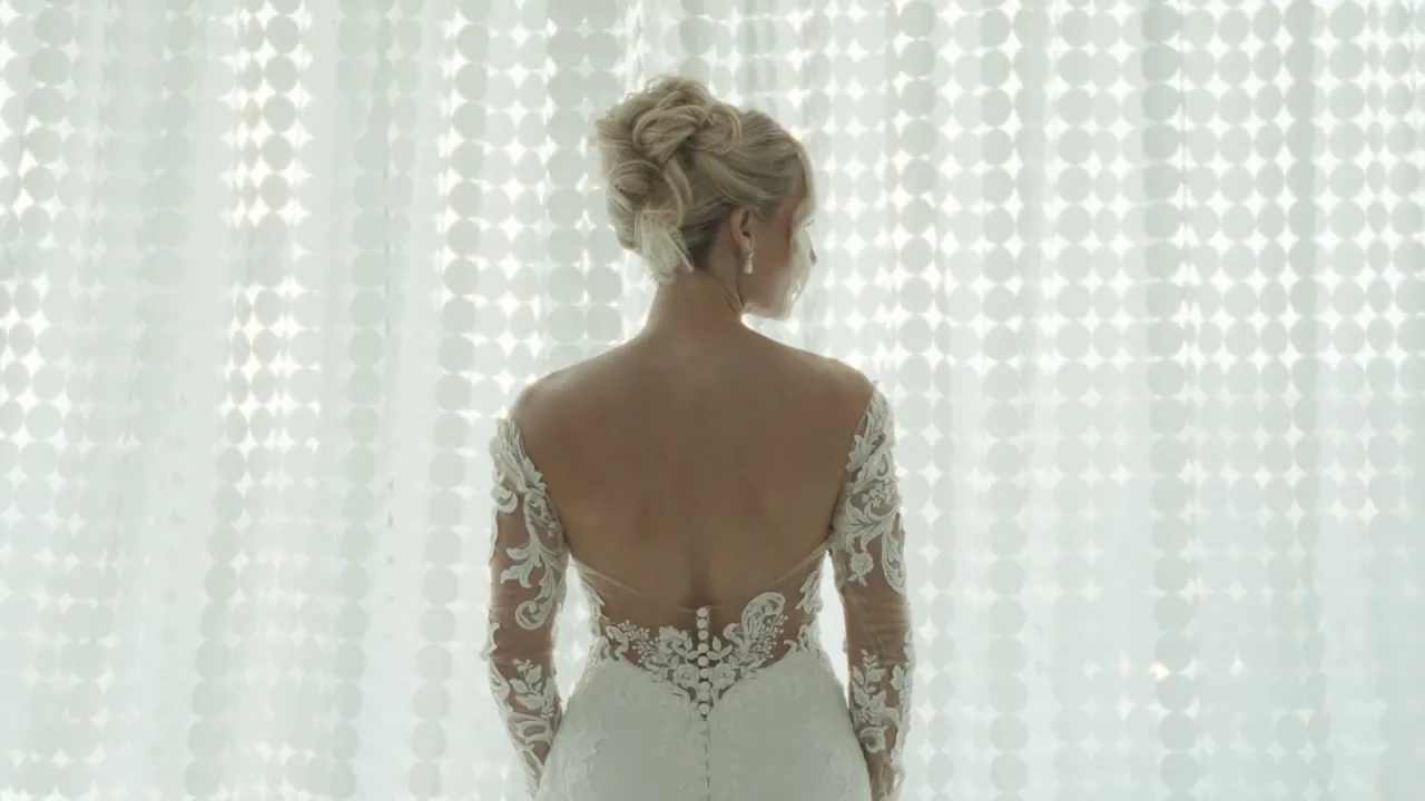 Katie in her wedding dress by a light-filled window before the ceremony